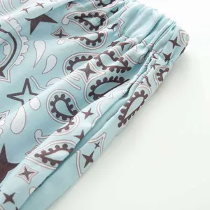 Close-up detail of light blue paisley print fabric featuring a flexible elastic waistband