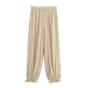 Vista dei dettagli dei pantaloni a lanterna plissettati beige con orlo a balze