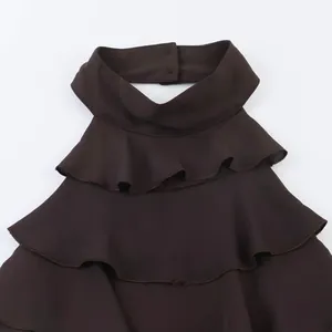Detailansicht eines braunen Halter-Tops mit gestuftem Rüschenkragen und Knopfverschluss