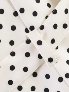 Close-up detail of white and black polka dot fabric with matching belt loop