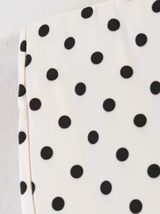 Detailed macro view showing the classic black and white polka dot pattern on soft fabric.