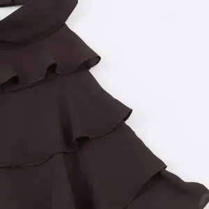 Nahaufnahme der gestuften schokoladenbraunen Rüschen eines eleganten Damen-Halterneck-Tops.