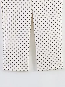 Detailed macro shot of white stretch trousers with a classic black polka dot pattern print