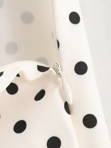 Macro view showing the high-quality invisible zipper on a white polka dot fabric set