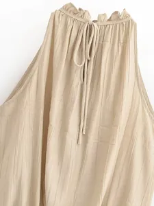 Dettaglio del top plissettato beige con collo a vogatore, volant e laccio da annodare.