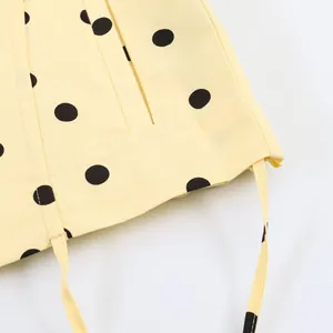 Detailaufnahme des gelben Stoffes mit schwarzen Punkten und Kordelzug für Damenbekleidung