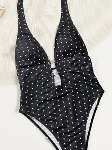 Dettaglio di un costume intero nero a pois bianchi con accenti di perle finte