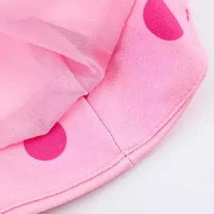Detailaufnahme des rosafarbenen Polka-Dot-Stoffs und des Netzfutters eines Oberteils.