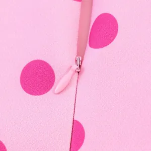 Nahaufnahme des unsichtbaren Reißverschlusses an rosa Oberteil mit roten Punkten
