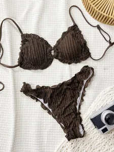 Detailed close-up view of dark brown textured ruffle bikini swimsuit set on white