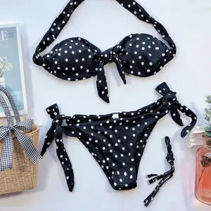Vue détaillée à plat d'un ensemble bikini chic à pois noirs et blancs avec nœuds