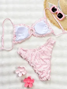 Close-up of pink ruffled bikini swimwear set with textured fabric for summer beachwear
