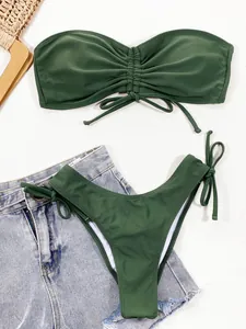 Detailopname van een olijfgroene gerimpelde bandeau bikini met zijwaartse strikjes