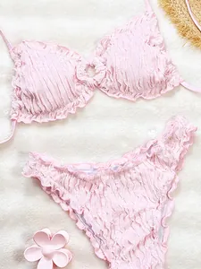 High-quality close-up of pink ruffled bikini set featuring textured smocking details
