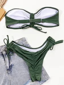 Detailweergave van donkergroene gerimpelde tweedelige bikiniset met denim shorts