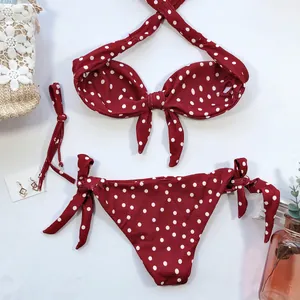 Vue à plat d'un ensemble bikini rouge à pois avec haut à nœud et bas à nouer sur les côtés.