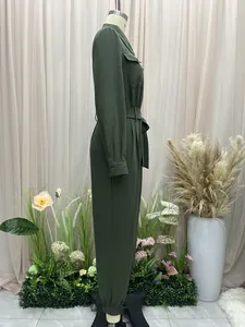 Side view of a dark green long-sleeved lapel jumpsuit featuring a stylish belted waist detail