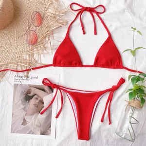 Flat lay detail of a bright red solid color triangle bikini set with coordinated summer props