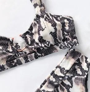 Nahaufnahme eines Damen-Bikinis mit Schlangenmuster und roségoldenem Metallring