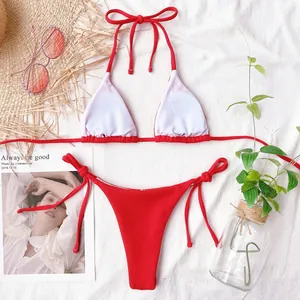 Close-up detail of a red ribbed bikini set laid out with decorative summer props.