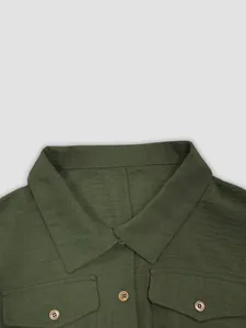 Macro view of olive green linen jumpsuit showing lapel collar and wood style buttons