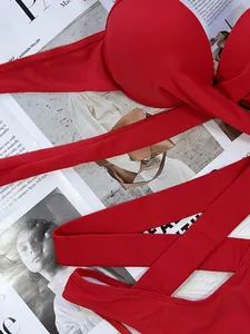 Detailed macro view of vibrant red solid bikini set featuring high waist wrap-around tie design