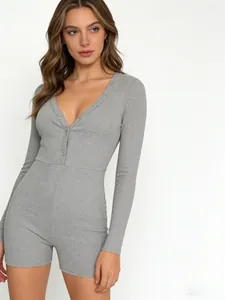 Dettaglio di una tutina grigia in maglia a coste con scollo a V profondo e bottoni