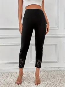 Vue détaillée du legging noir taille haute avec ourlet en dentelle florale élégante.