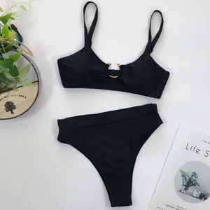Draufsicht auf ein schickes schwarzes High-Waist-Bikini-Set mit Metallring auf weißem Grund