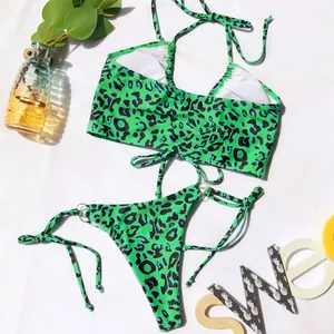 Ensemble bikini léopard vert vif posé à plat avec des accessoires de décoration d'été.