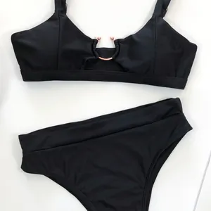 Detailansicht eines schwarzen Bikini-Oberteils mit elegantem roségoldenem Ringdekor