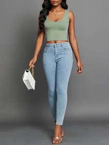 Close-up of avocado green V-neck ribbed crop tank top worn with blue skinny jeans