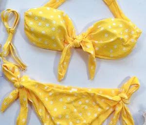 Gros plan détaillé d'un bikini jaune à pois avec tissu texturé et jolis nœuds noués