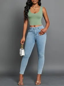 Close-up of avocado green ribbed v-neck crop top shown on a model with blue denim jeans.