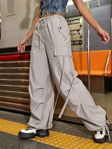 Detailansicht der grauen Cargo-Hose für Damen mit Bändern und funktionalen Taschen.