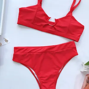 Flach liegendes Detail eines roten zweiteiligen Bikinis mit hoher Taille und Ring-Detail.