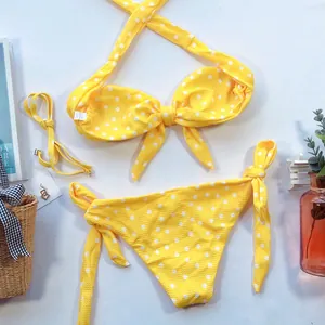 Ensemble bikini jaune à pois blancs avec nœud frontal et liens sur les côtés.