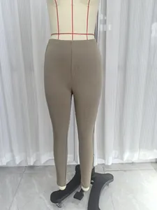 Detailopname van de kaki stretch-legging met hoge taille op een paspop voor een slanke vorm
