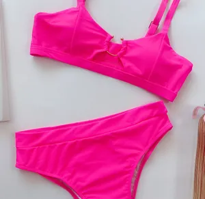 Nahaufnahme eines leuchtend neonpinken Bikinis mit Goldring-Detail und verstellbaren Trägern.