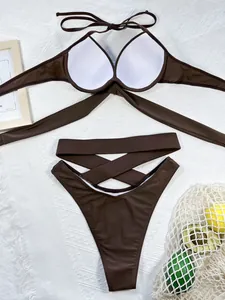 Detailed macro view of dark brown high-waisted bikini with stylish criss-cross straps