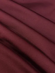 Macro detail of elegant burgundy knit fabric showing soft texture and natural folds