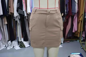 Macro view of a khaki knitted cargo mini skirt with large side pockets shown on a mannequin.