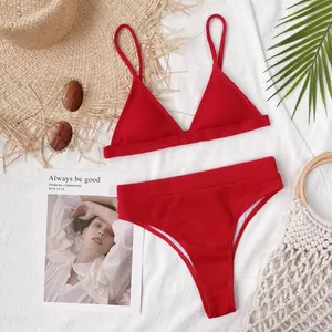 Detalle de un conjunto de bikini de dos piezas de canalé rojo en tela blanca