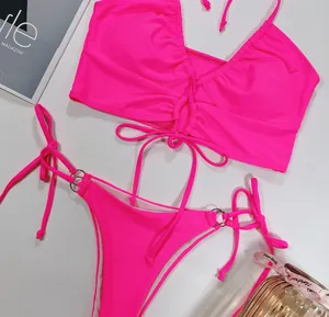 Vue détaillée d'un haut de bikini froncé rose néon et d'un bas à nouer avec anneaux