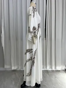 Side view of white Bohemian maxi dress featuring brown feather prints and batwing sleeves