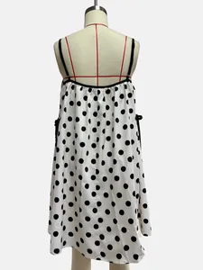 Close-up back view of a white summer dress with black polka dots on a mannequin