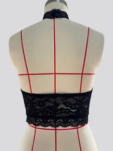 Vista posteriore dettagliata di un crop top all'americana in pizzo nero con motivi traforati