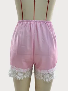 Back view of pink satin pajama shorts with delicate white lace trim on mannequin