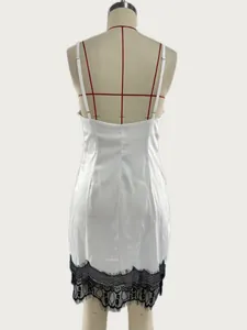 Achteraanzicht van een witte satijnen slipdress met elegante zwarte kanten bies aan de zoom