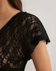 Detailed view showing the intricate floral lace pattern on a black Y2K mesh top